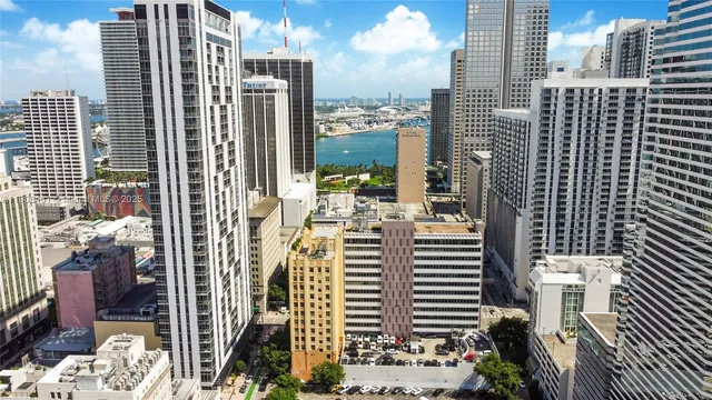 a view of a balcony with a couple of cars parked in front of buildings
