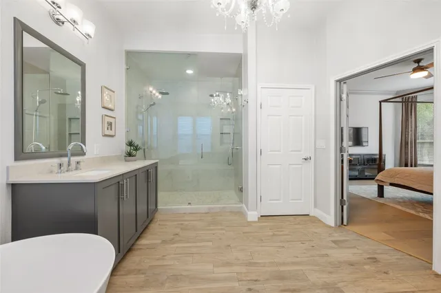 a bathroom with a double vanity sink a toilet a mirror and shower