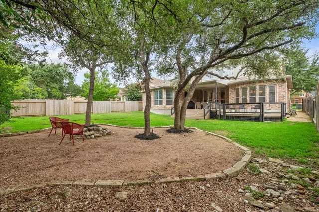 a view of a house with a backyard and a tree