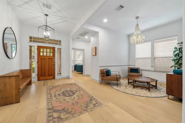 a living room with furniture chandelier and a window