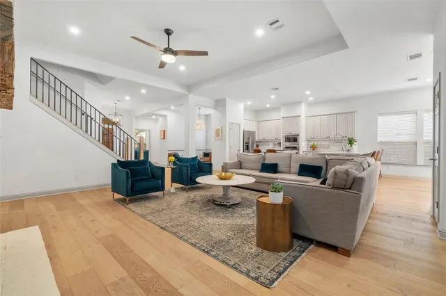 a living room with furniture kitchen view and a chandelier