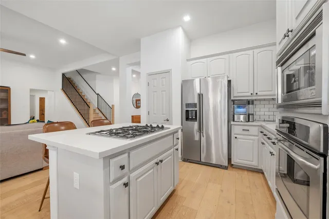 a kitchen with stainless steel appliances granite countertop a sink stove and refrigerator