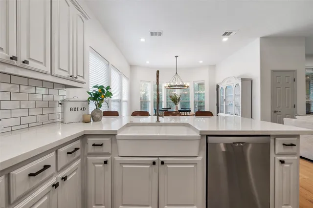 a kitchen with stainless steel appliances granite countertop a sink and a white wooden cabinets