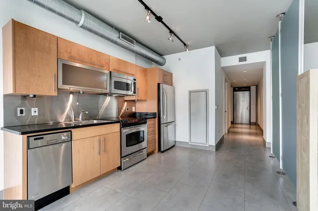 a kitchen with granite countertop a sink and stainless steel appliances