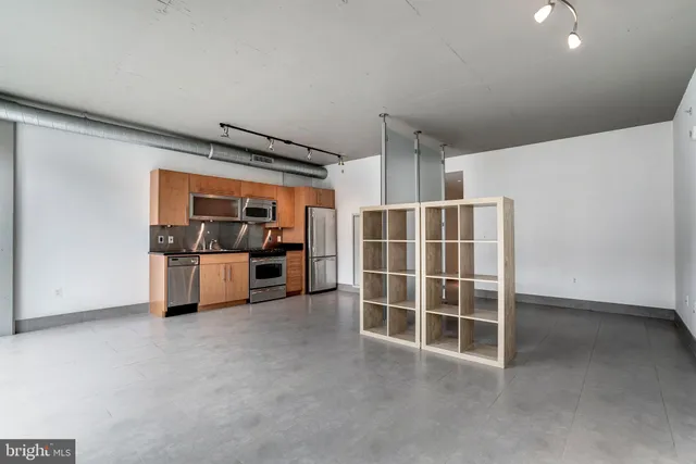 a view of kitchen with refrigerator and more cabinets