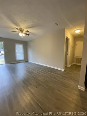 a view of a livingroom with a ceiling fan window and wooden floor