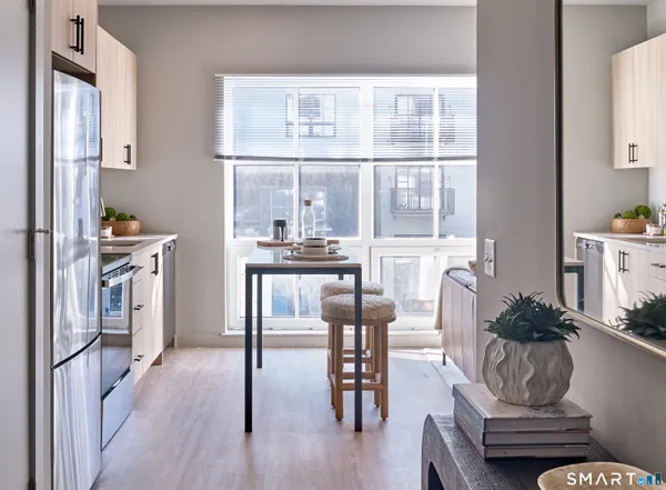 a living room with furniture a dining table and a window
