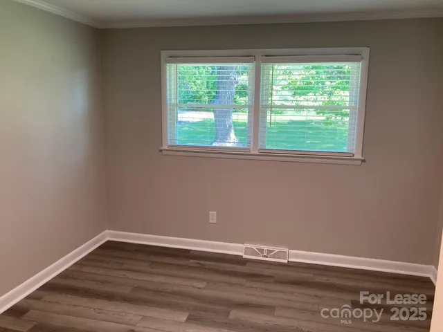 a view of a room with wooden floor and natural light