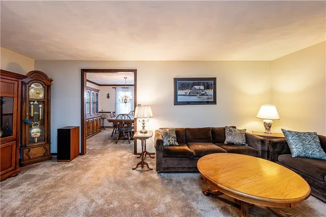 a living room with furniture a lamp paintings and a window