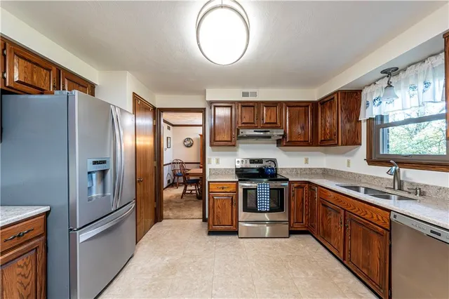 a kitchen with stainless steel appliances granite countertop a refrigerator stove and sink