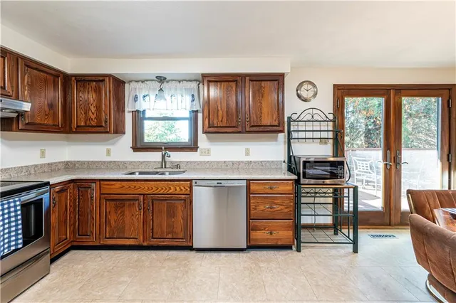 a kitchen with stainless steel appliances granite countertop a stove a sink and a refrigerator
