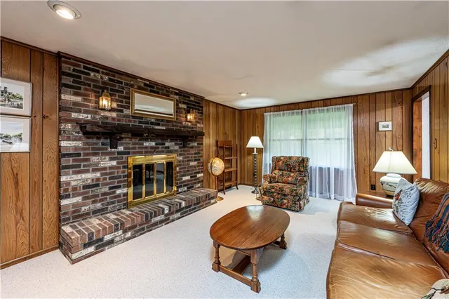 a living room with furniture a fireplace and a floor to ceiling window