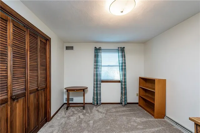 a view of an empty room and kitchen