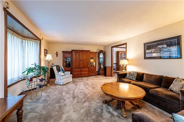 a living room with furniture potted plant and wooden floor