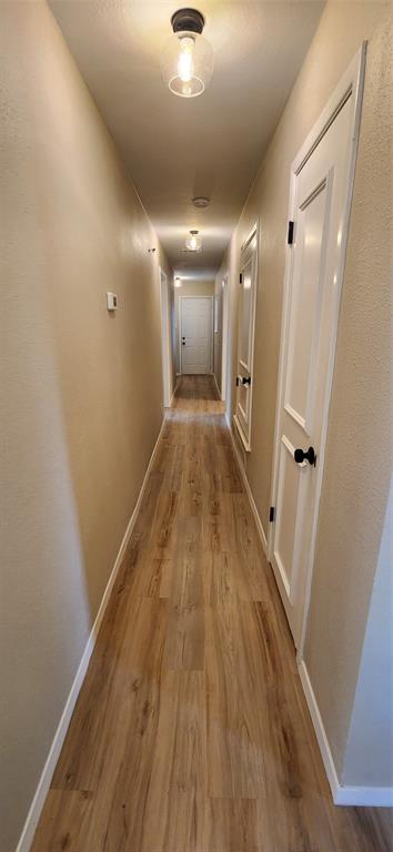 2821 Windy Drive Commerce, TX 75428 - Photo 11 of 25 a view of a hallway with wooden floor