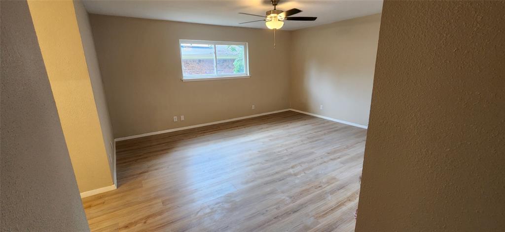 2821 Windy Drive Commerce, TX 75428 - Photo 23 of 25 an empty room with wooden floor and windows