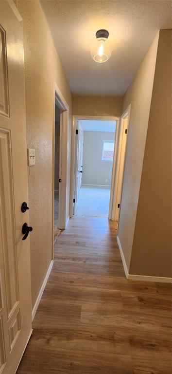 2821 Windy Drive Commerce, TX 75428 - Photo 9 of 25 a view of a hallway with wooden floor