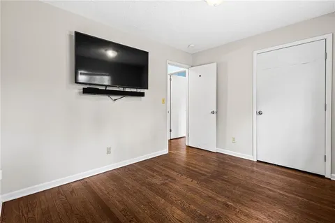 a view of a livingroom with wooden floor and a flat screen tv