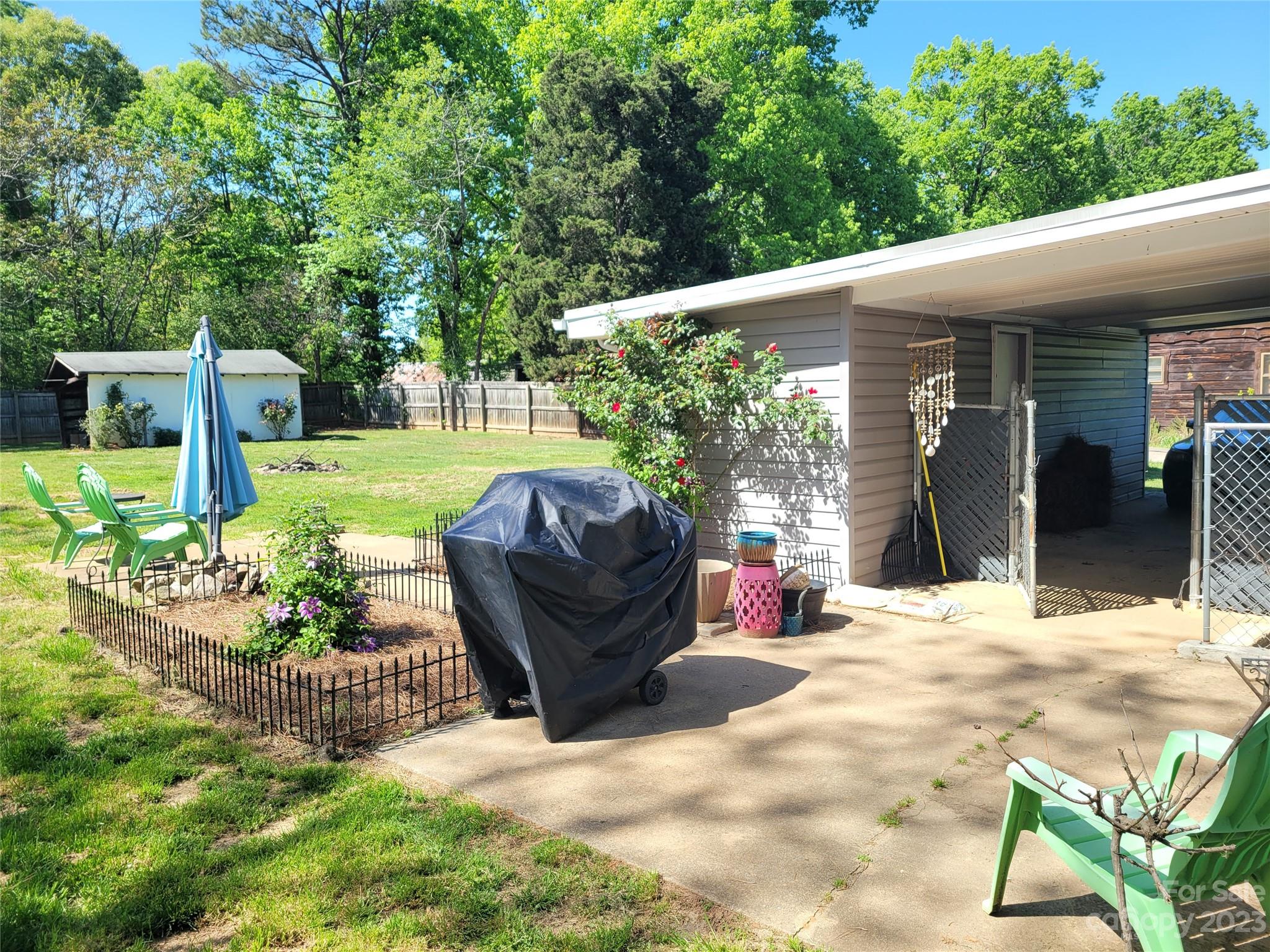 1740 Sells Road Salisbury, NC 28144 - Photo 3 of 22 a view of a patio with table and chairs potted plants and large tree