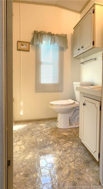 1601 Highway 441, Unit 3 Okeechobee, FL 34974 - Photo 13 of 17 a bathroom with a toilet a sink and a window