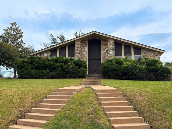 a view of brick house with a yard