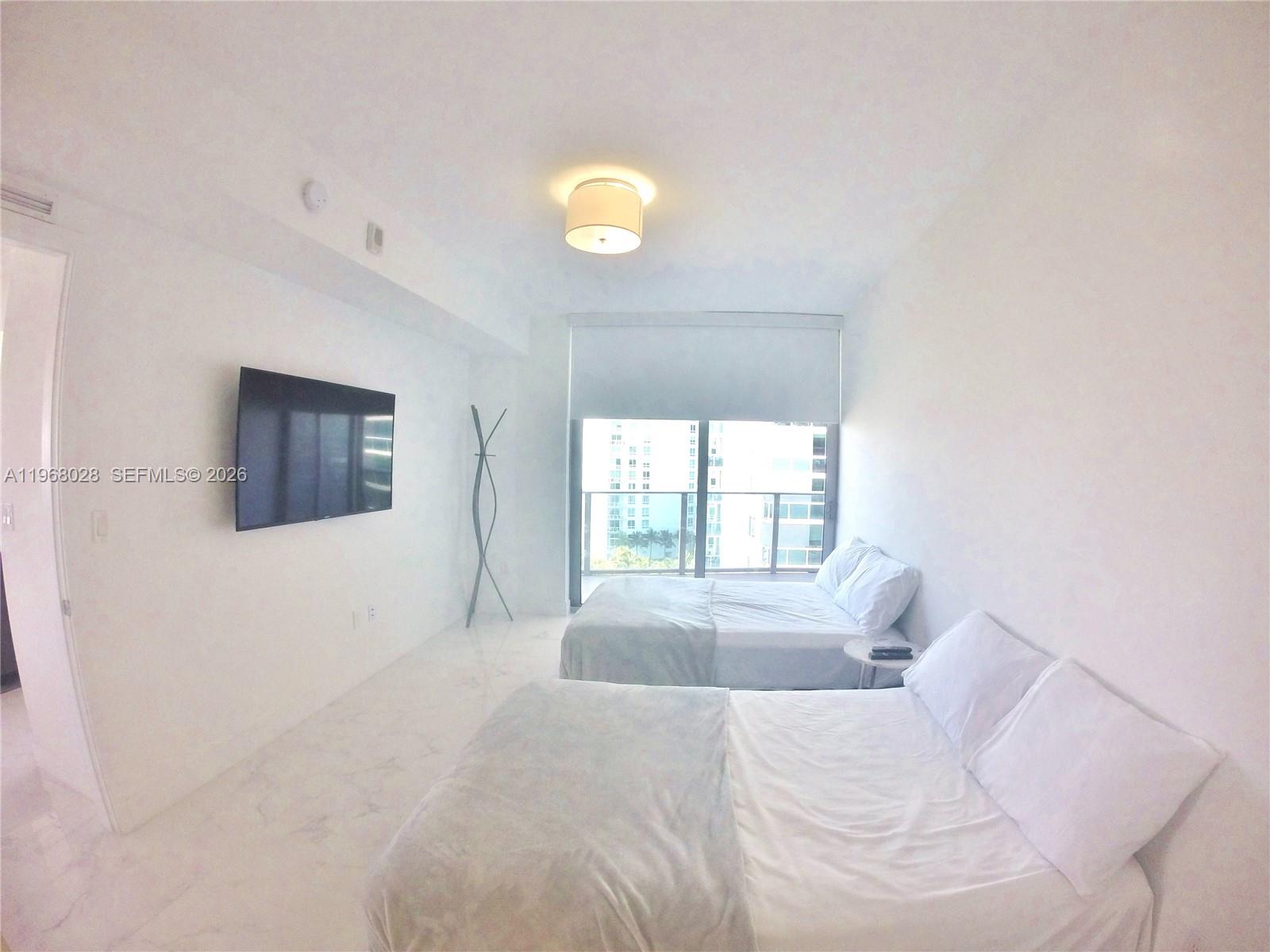 488 Northeast 18th Street, Unit 2001 Miami, FL 33132 - Photo 12 of 26 a bedroom with a bed and a window