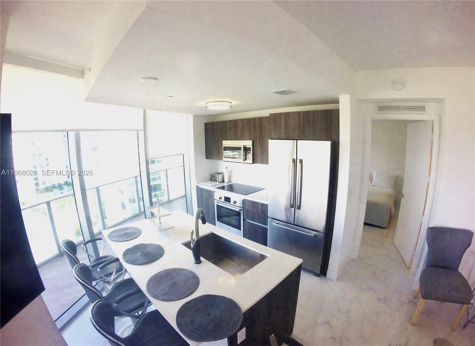 488 Northeast 18th Street, Unit 2001 Miami, FL 33132 - Photo 4 of 26 a view of a dining room with furniture a kitchen and wooden floor
