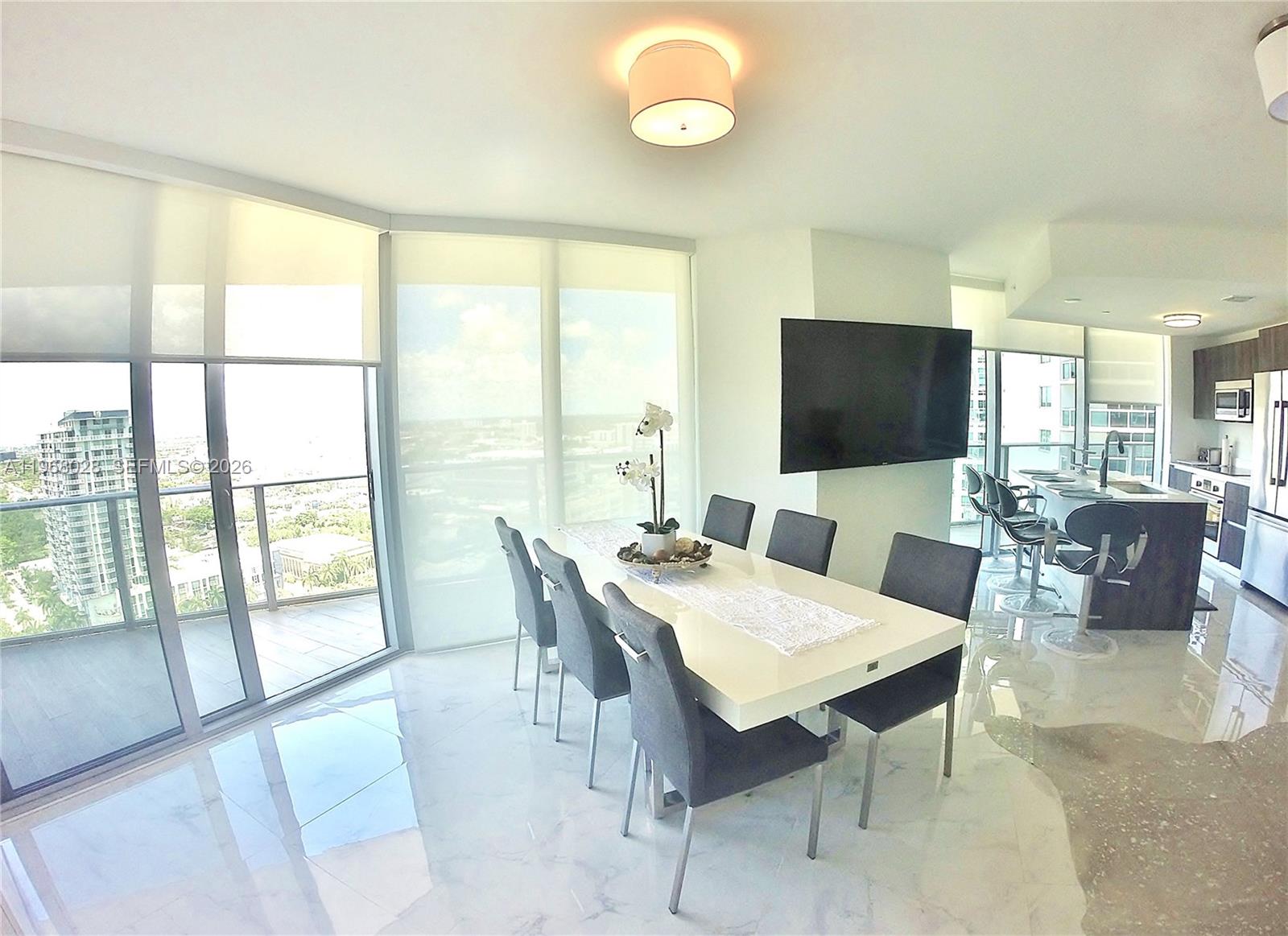 488 Northeast 18th Street, Unit 2001 Miami, FL 33132 - Photo 6 of 26 a view of a dining room with furniture window and wooden floor