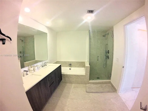 a bathroom with a tub sink and mirror