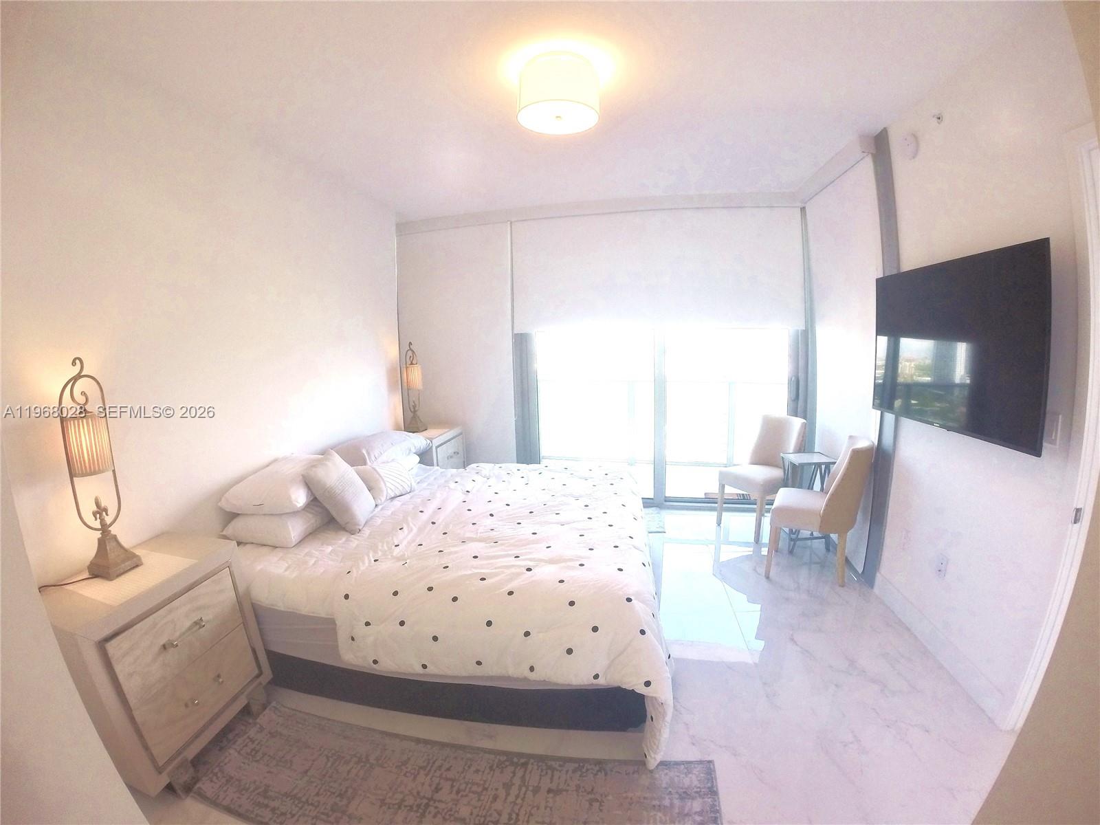 488 Northeast 18th Street, Unit 2001 Miami, FL 33132 - Photo 9 of 26 a living room with furniture and a flat screen tv