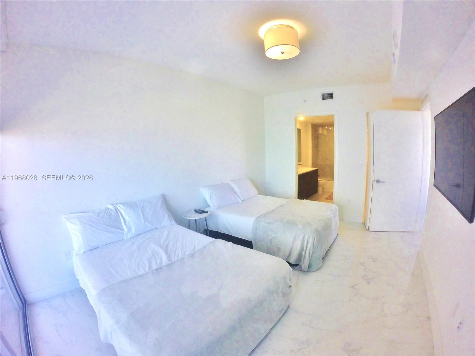 488 Northeast 18th Street, Unit 2001 Miami, FL 33132 - Photo 10 of 26 a bedroom with a bed and painting on the wall