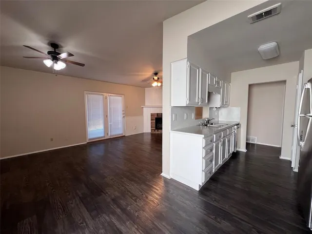 a view of a kitchen with a sink a ceiling fan and wooden floor