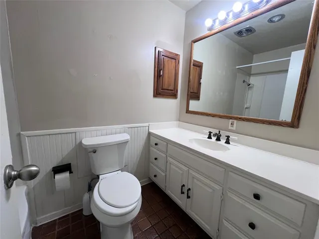 a bathroom with a toilet sink and mirror