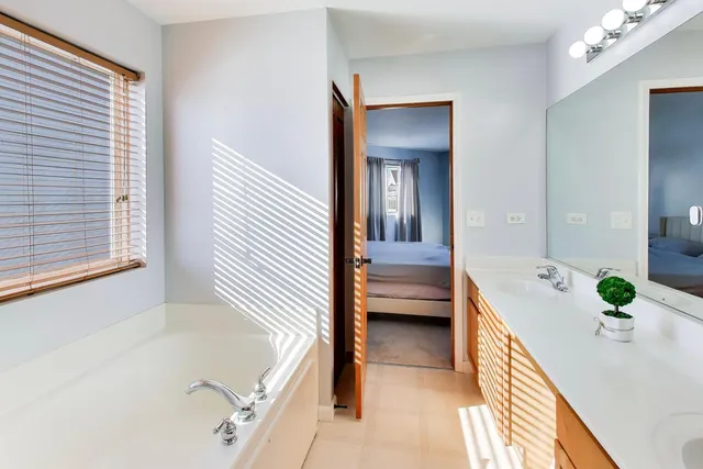 a bathroom with a tub sink and mirror