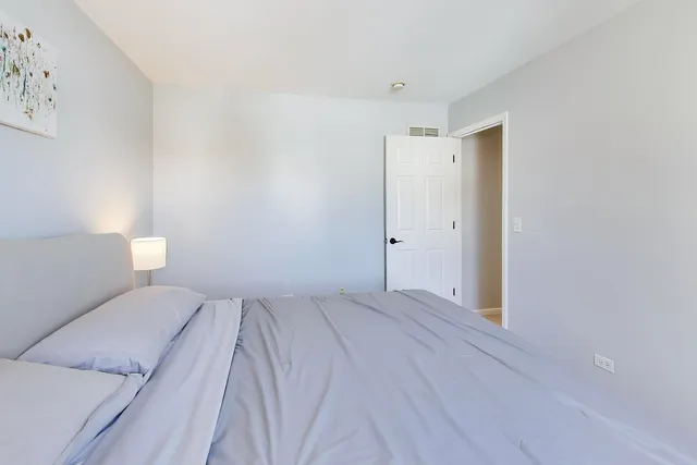 a view of a bedroom with wooden floor and bathroom
