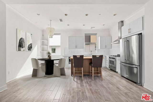 a kitchen with kitchen island wooden floors and stainless steel appliances