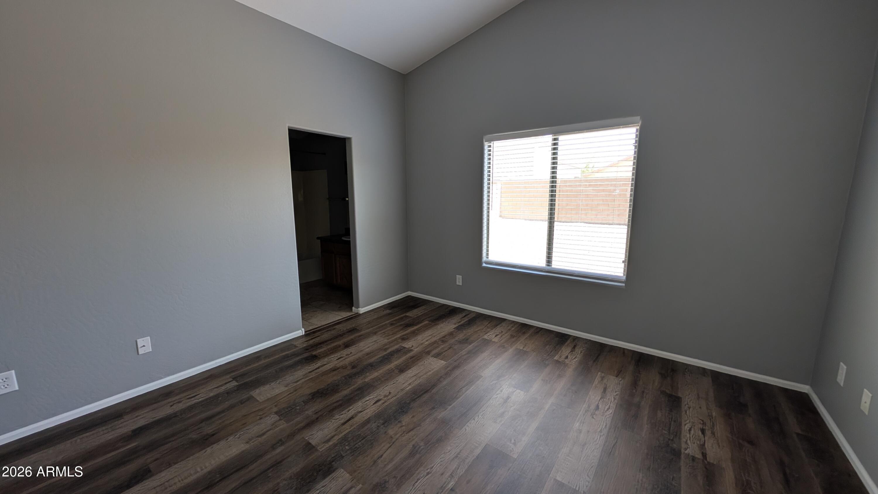 1377 East Pryor Road San Tan Valley, AZ 85140 - Photo 7 of 31 a view of an empty room with wooden floor and a window
