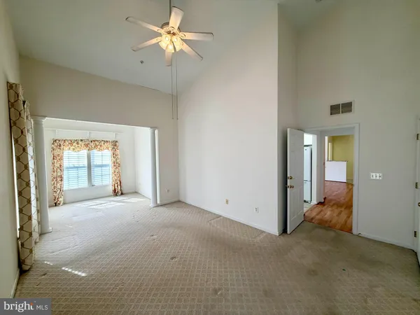 a view of a big room with chandelier fan and windows
