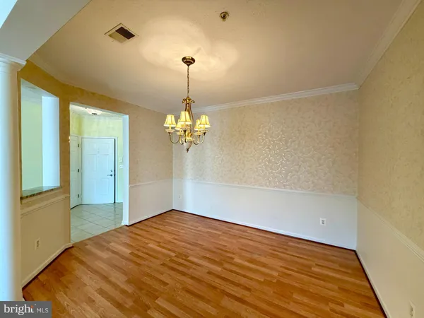 a view of empty room with a chandelier fan and wooden floor
