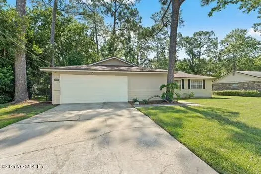 a front view of a house with a garden and yard