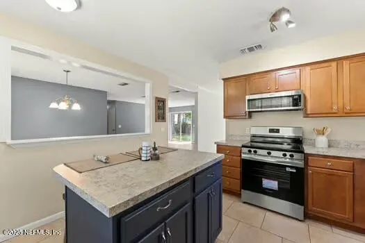 a kitchen with stainless steel appliances granite countertop a stove a sink and a microwave