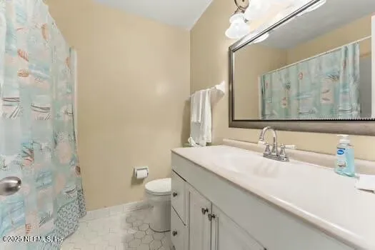 a bathroom with a granite countertop sink a toilet and a mirror