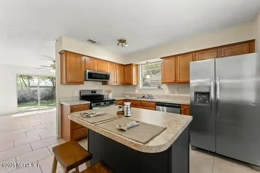 a kitchen with stainless steel appliances granite countertop a sink stove microwave and refrigerator