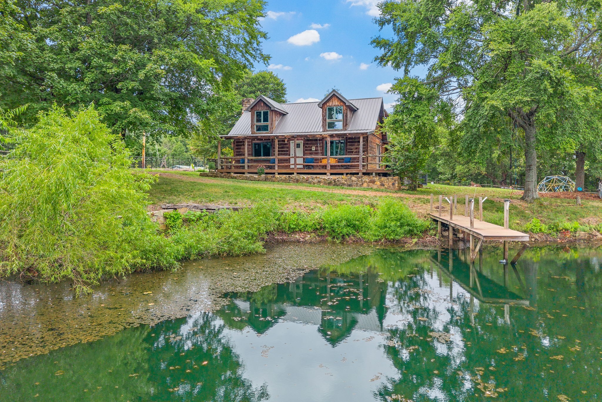 a front view of a house with a yard and lake view