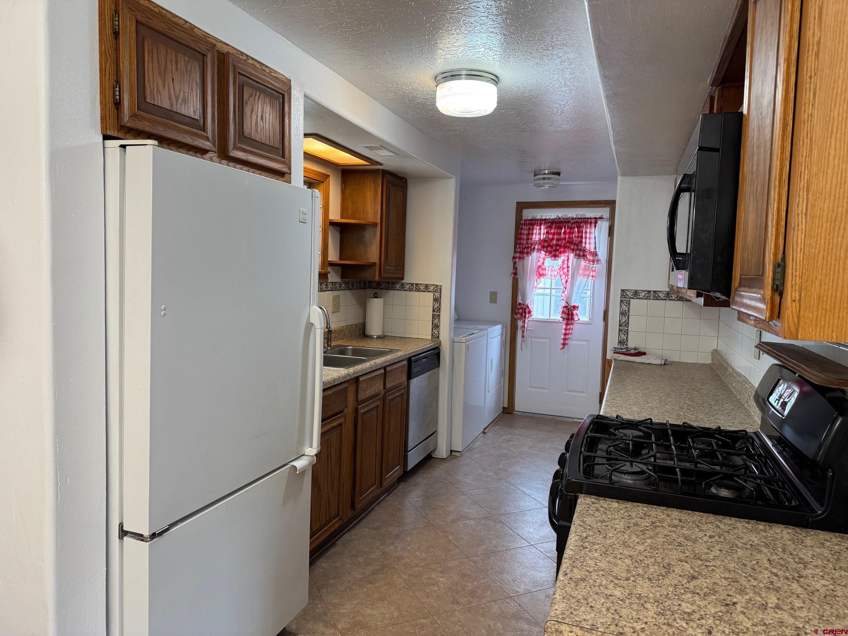 425 West 7th Street Cortez, CO 81321 - Photo 12 of 22 a kitchen with stainless steel appliances granite countertop a refrigerator and a stove