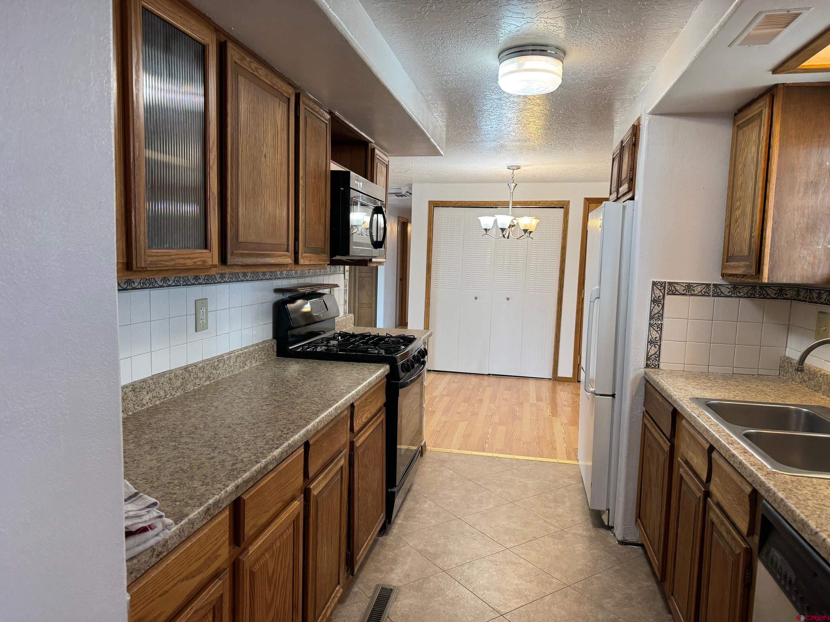 425 West 7th Street Cortez, CO 81321 - Photo 13 of 22 a kitchen with a refrigerator and a sink