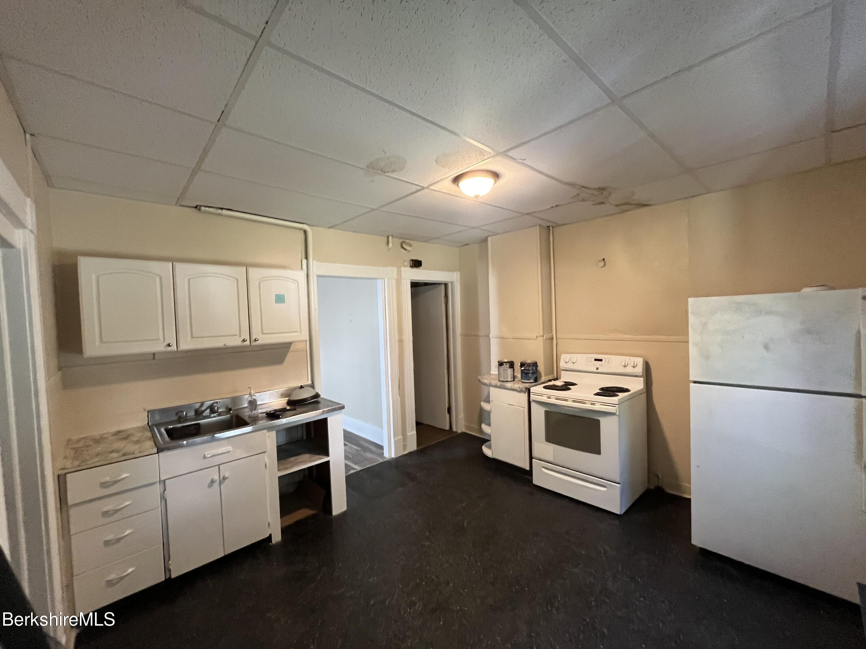 21 Blackinton Street, Unit 1 North Adams, MA 01247 - Photo 10 of 13 a kitchen with cabinets and white appliances