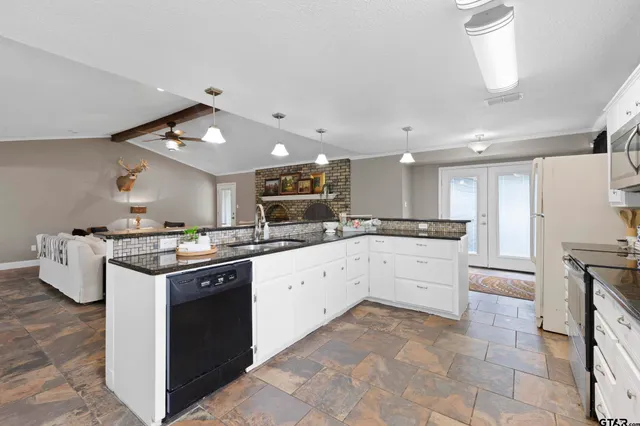 a large kitchen with stainless steel appliances granite countertop a stove and a sink