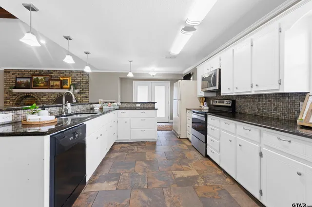 a large kitchen with stainless steel appliances lots of counter space sink and cabinets