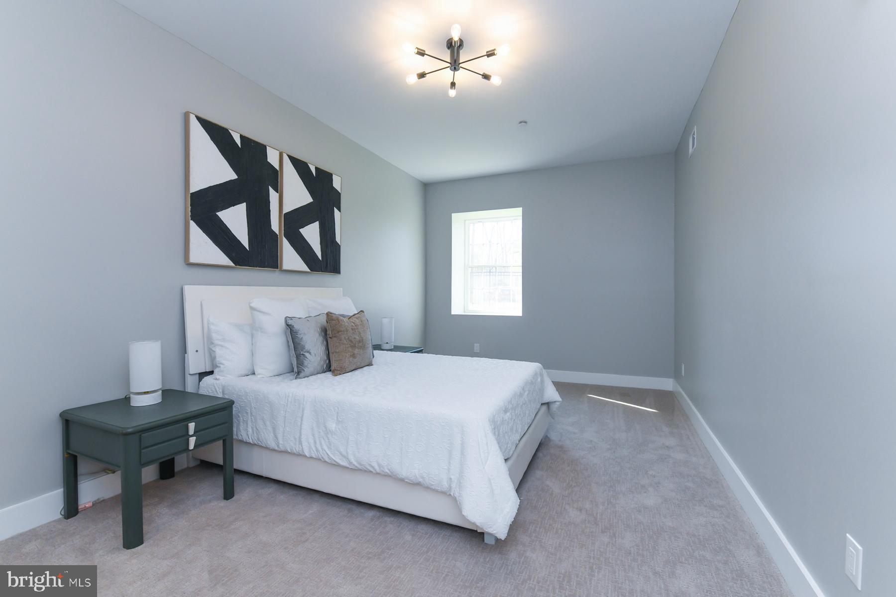 100 Aura Road, Unit 110 Clayton, NJ 08312 - Photo 13 of 21 a bedroom with a bed and a painting on the wall